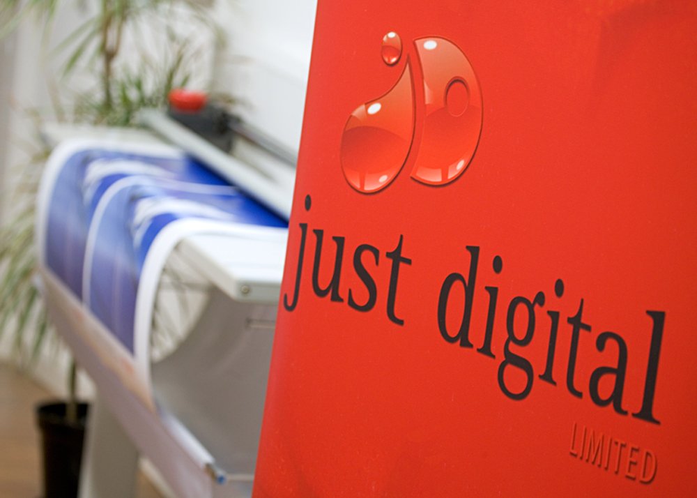 Red banner with the logo and text 'just digital LIMITED', blurred printer and documents in the background.
